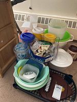 Various plastic containers, lids, large mixing bowls, container with cookie cutters, and brown plastic food tray