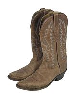 Pair of brown Old West cowboy boots with pointed toes, decorative stitching, and pull tabs. Visible dirt and wear on leather surfaces.