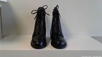 Front view of pair of black lace-up leather boots showing toe, laces and overall shape