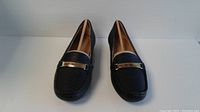 Front view of black Naturalizer Gadget women's loafers showing textured surface and gold accent.