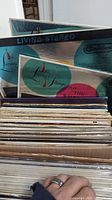 Two boxes filled with assorted vinyl LP records with visible covers such as 'Living Stereo' and 'Funky Strings.'