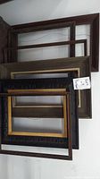 Stack of six antique wooden frames showing varying sizes and finishes