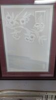 Photo of framed print showing floral design with white blossoms on branches, framed in dark wood with white and blue mats.