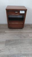 Front view showing the two drawers separated by the middle shelf area, with a metal pull handle on top drawer, medium brown finish.