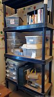Three-tier shelving unit with multiple storage bins and organizers