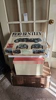 Stacked cardboard boxes with 1930 Bentley kit on top