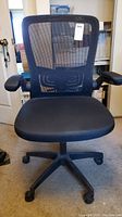 Front view of the black office chair with mesh back and padded seat.