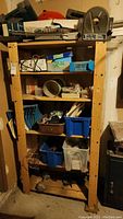 Wooden shelving unit filled with various garage items, showing five shelves and construction details.