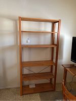 Full frontal view of the wooden shelf unit with 5 adjustable shelves, showing its height and overall condition.