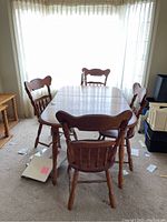 Full view of wooden dining table with four chairs around it.