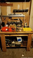 Front view showing workbench surface with plastic bins and pegboard with tools