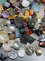 Close-up image showing a variety of faceted and polished genuine gemstones in multiple colors and shapes.
