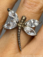 Close-up photo of the sterling silver dragonfly ring showing detailed body and clear crystals as wings, worn on finger, showcasing size and design.