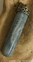 Close up of fossilized coral stone pendant with silver cap showing pattern and wear.