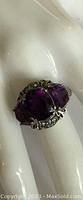 Front view showing the large central purple gem and two smaller purple gems on the sides, with clear crystal accents.