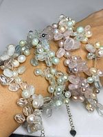 Four sterling silver bracelets with gemstone and pearl clusters displayed on wrist and laid flat showing detail and chain ends with heart-shaped charms.