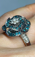 Top-down view of ring on finger showing flower design