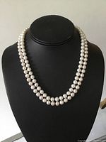 Double strand saltwater pearl necklace displayed on bust showing pearl size and shine.