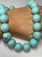 Close-up of chunky light blue turquoise beads with brown matrix veining.