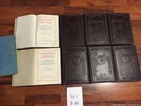 Complete set of 8 hardcover volumes with embossed front covers and visible spines, arranged on a wooden floor.