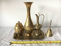 Full set of five Indian style brass/copper vessels and tray arranged with measuring scale for size reference