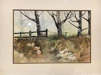 Front view of framed watercolor painting showing natural landscape with three trees and wooden fence, signed by Judy Puil