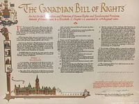 Close-up photo of The Canadian Bill of Rights document showing title, introduction paragraph, sections, and decorative coats of arms with building image at bottom corner in original wrapping