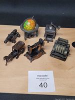 Photo showing all six metal pencil sharpeners arranged on wood surface with auction card