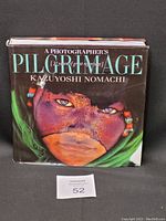 Front cover of the photo book showing a close-up portrait with face paint and beads, title visible.