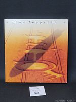 Closed boxed set showing cover art with orange crop circle design and 'Led Zeppelin' text.