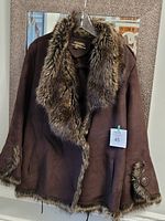 Front view of brown suede style women's winter jacket with faux fur trim on collar, front edges, cuffs, and hem. Jacket appears warm and clean.