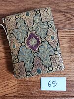 Front cover of the 1930s diary with detailed gold and turquoise decorative design and maroon central pattern.