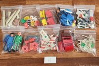 Multiple small resealable bags containing various Playmobil figures, accessories, and parts organized on a wooden surface.