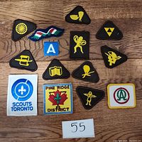 Full view of all 14 patches laid on wooden surface showing their designs and shapes