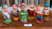 Front view of all six Disney Snow White Dwarfs figurines arranged side-by-side showing full set.