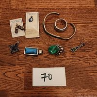 All 8 sterling silver jewelry pieces on wooden background