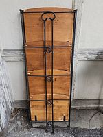 Back view of wooden and metal shelf unit showing metal frame and wooden panels with natural wood grain and wear marks.