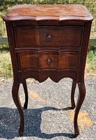 Front view of wooden cabriole leg side table showing shaped front, two drawers with wooden knobs, curved edges, and wood finish.