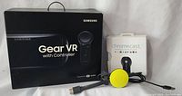 Samsung Gear VR headset in original box with controller shown alongside one Google Chromecast streaming device with yellow HDMI dongle in original box