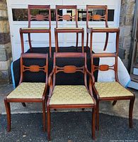 Front view of six Georgian style mahogany dining chairs with floral gold upholstery, showing shaped top rails and decorative back stretchers.