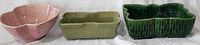 Front view of three flower planters: pink art deco brick pattern pot, olive green McCoy rectangular planter, and green glazed UPCO planter.