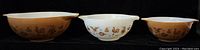 Front view of three Pyrex Early American Cinderella mixing bowls showing patterns and size variation