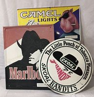 Photo showing all three tin tobacco advertisement signs: Camel Lights, Skoal Bandits, and Marlboro with visible wear.