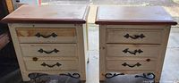 Pair of used Vaughan Furniture Company two drawer nightstands showing front view with metal leaf handles and distressed cream finish.