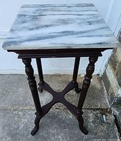 Square top view of white marble with gray veining on plant stand