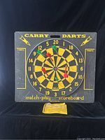 Front view of the vintage Carry Darts board with darts attached.