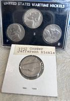 Four Jefferson nickels displayed, three wartime nickels in a black plastic case labeled 'United States Wartime Nickels' with mint marks P, S, and D, and one 1952 copper Jefferson nickel in a white cardboard sleeve.