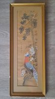 Vertical watercolour painting of a colorful bird on a tree branch with calligraphy, framed in gold.