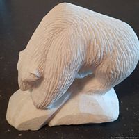 Side view showing carved fur texture and bear posture on base