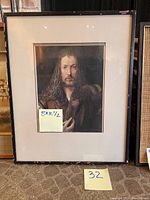 Framed print showing the man with long curly hair, beard, wearing fur-collared garment. Black wooden frame visible. Photo includes measurement post-it 8" x 10.5" and lot number post-it 32.